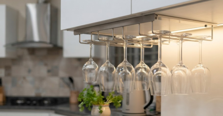 Stainless steel under cabinet glass holder with hanging stemware in a modern Dhaka kitchen.